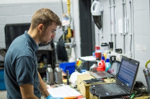 Apprentice vehicle technician checking results on Laptop