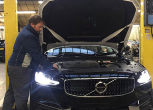 A vehicle technician working on a Volvo car
