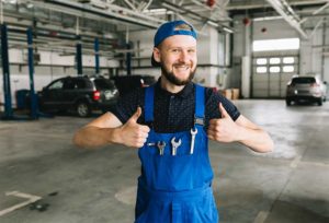 Happy vehicle technician holding his thumbs up