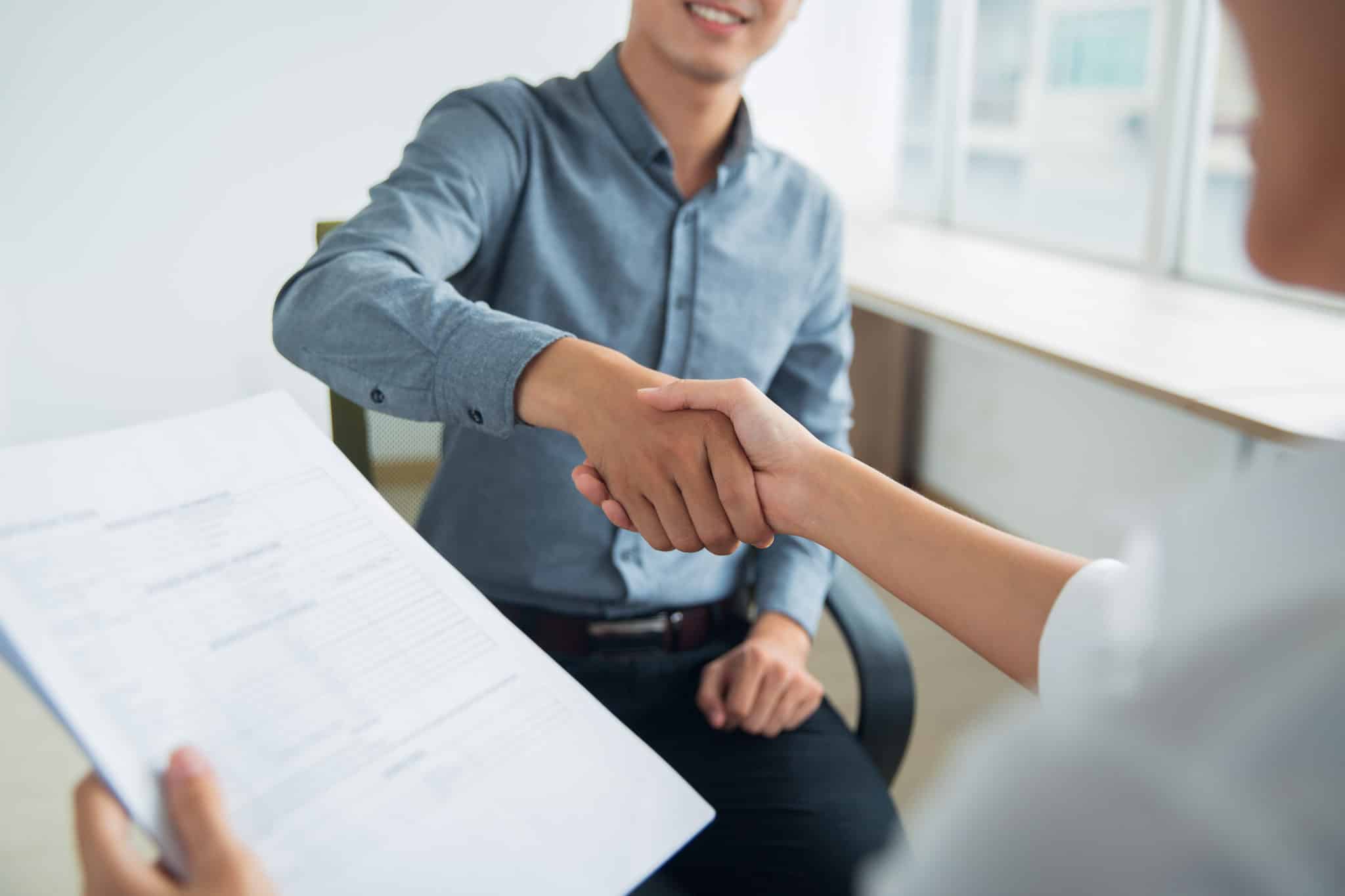 Two people shaking hands in a job interview