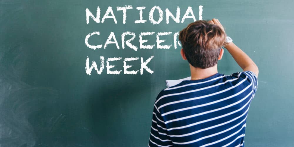 School pupil writing National Careers Week on a blackboard in chalk