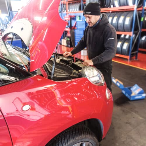 Contract Vehicle Technician Roberto working on the engine of a red car for Autotech Recruit